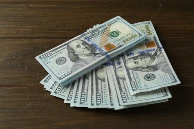 Photo of Pile of dollar banknotes on wooden table