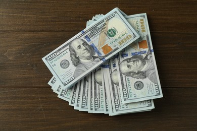 Many dollar banknotes on wooden table, top view