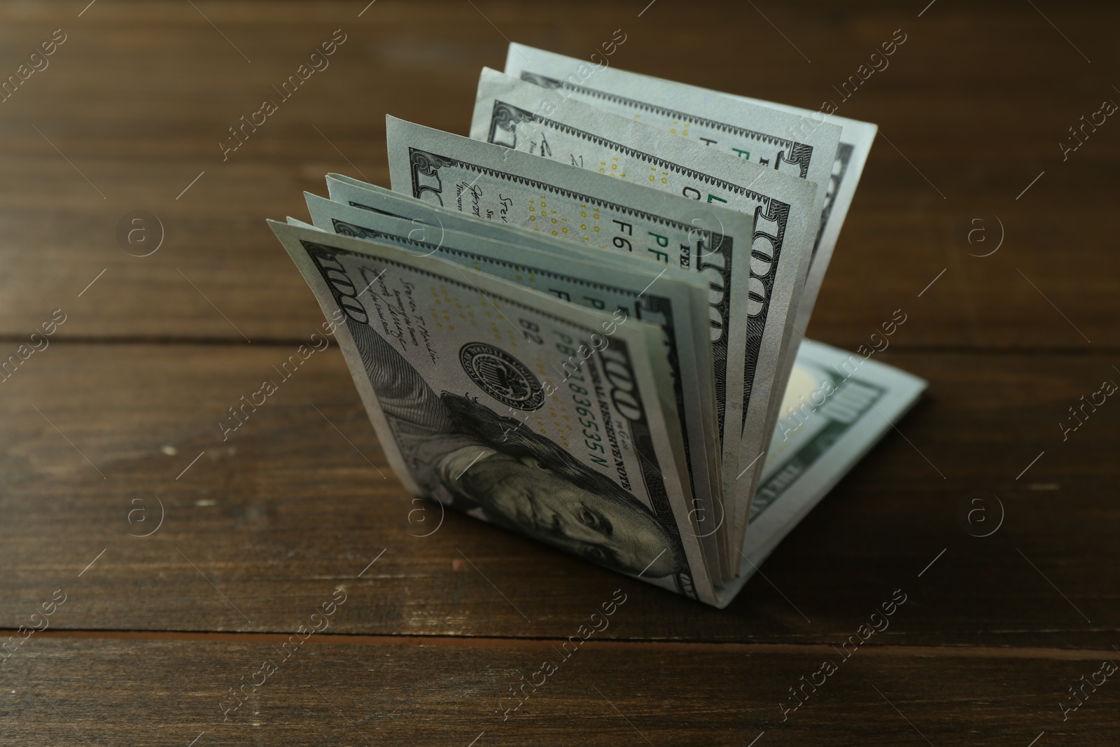 Photo of Many dollar banknotes on wooden table, closeup