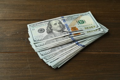 Photo of Pile of dollar banknotes on wooden table