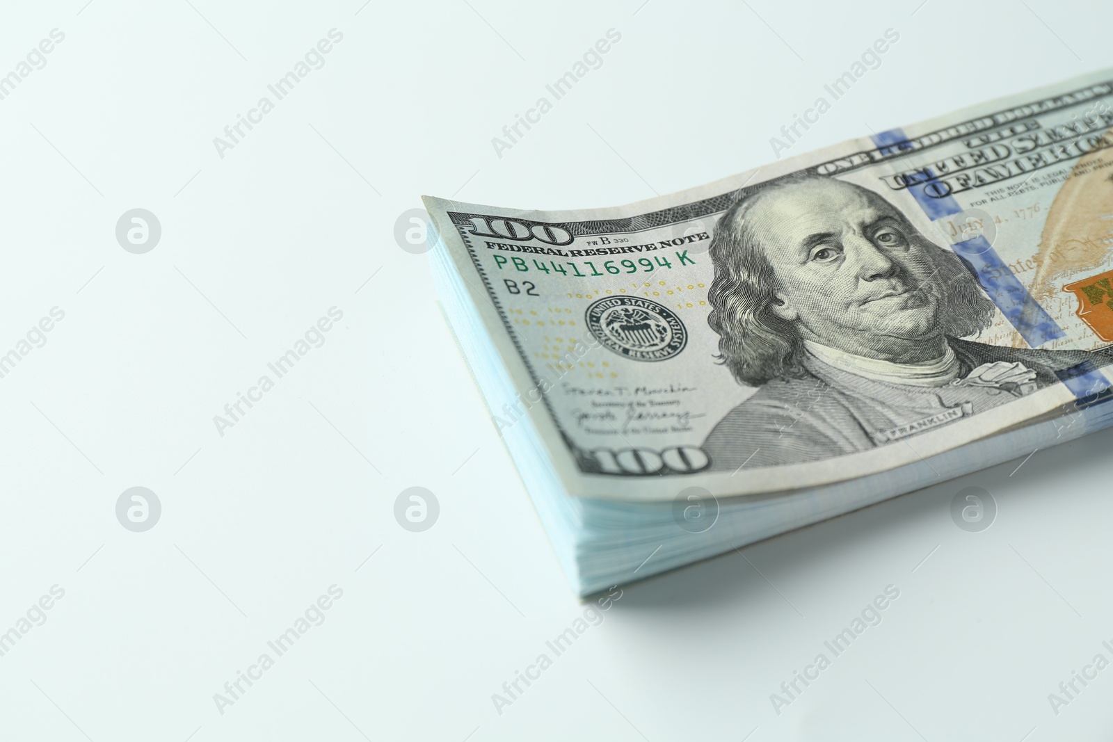 Photo of Stack of dollar banknotes on white background, closeup. Space for text