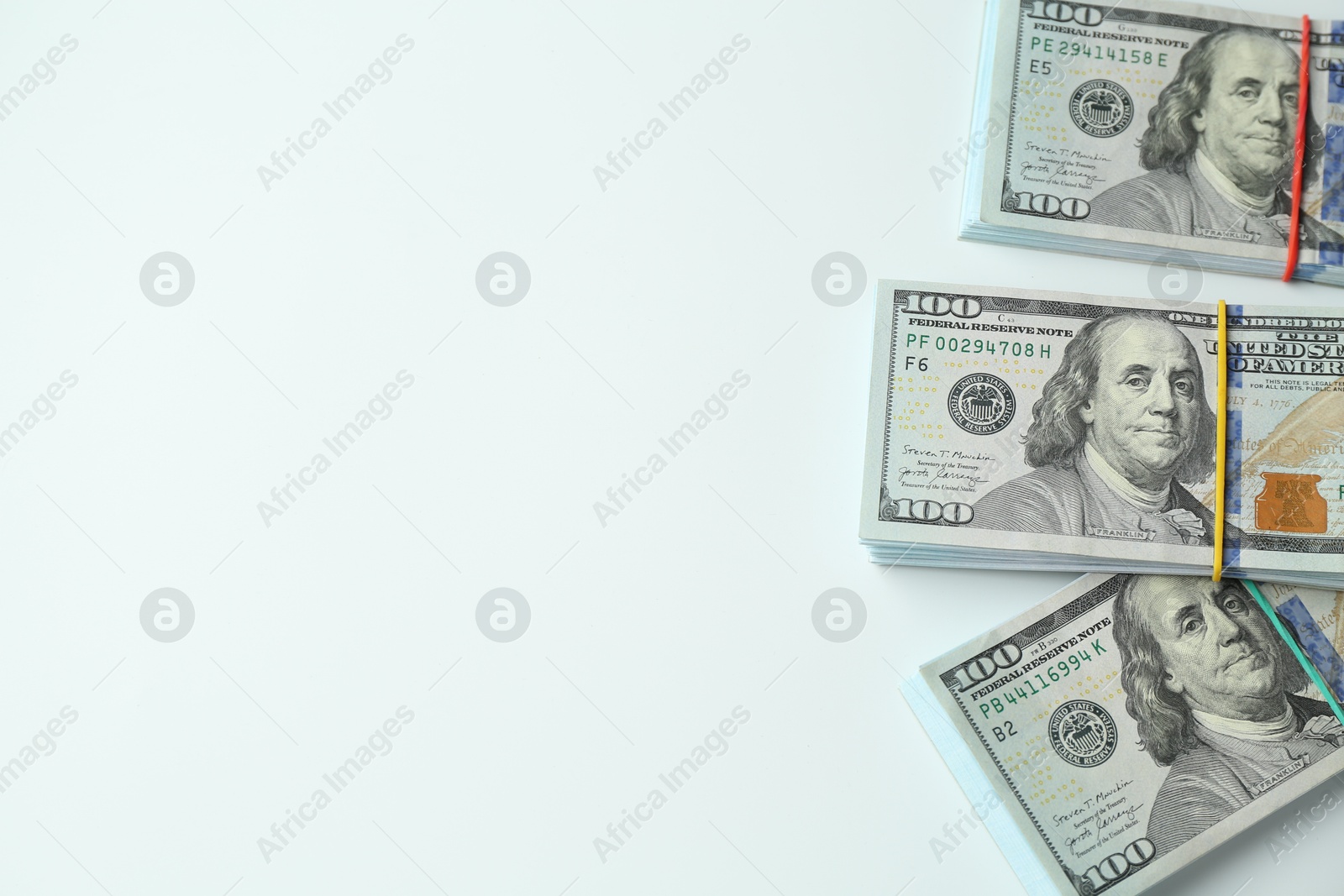 Photo of Bundles of dollar banknotes on white background, top view. Space for text