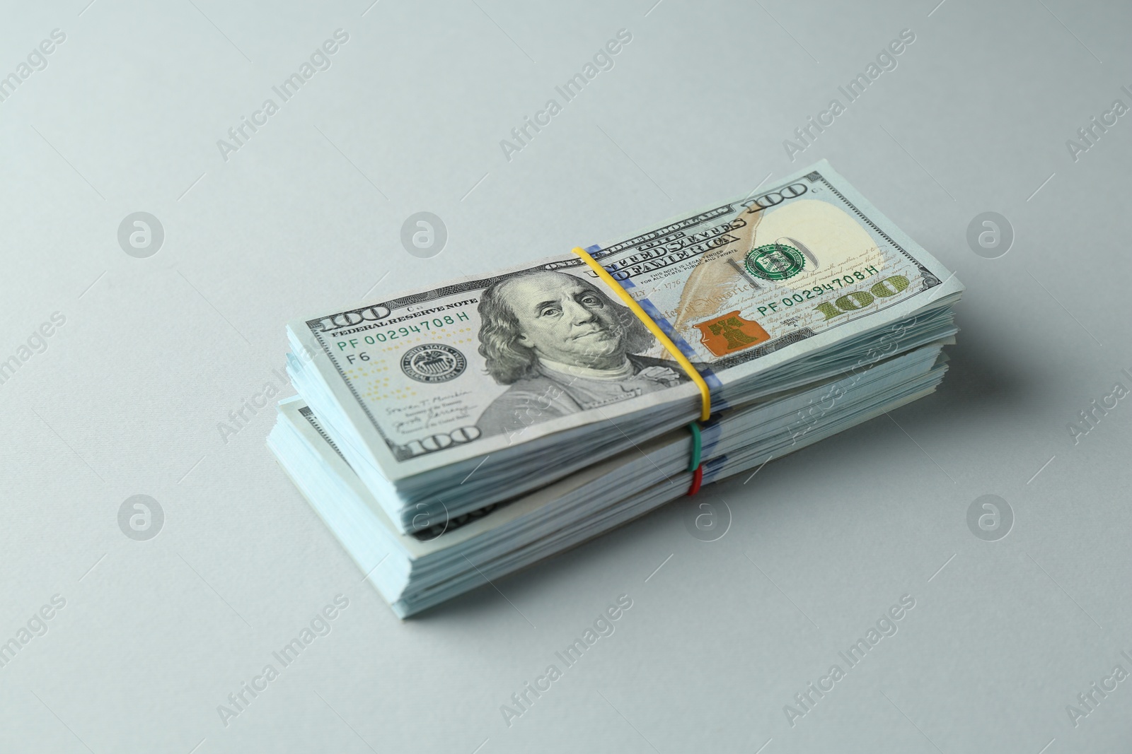 Photo of Bundles of dollar banknotes on light grey background