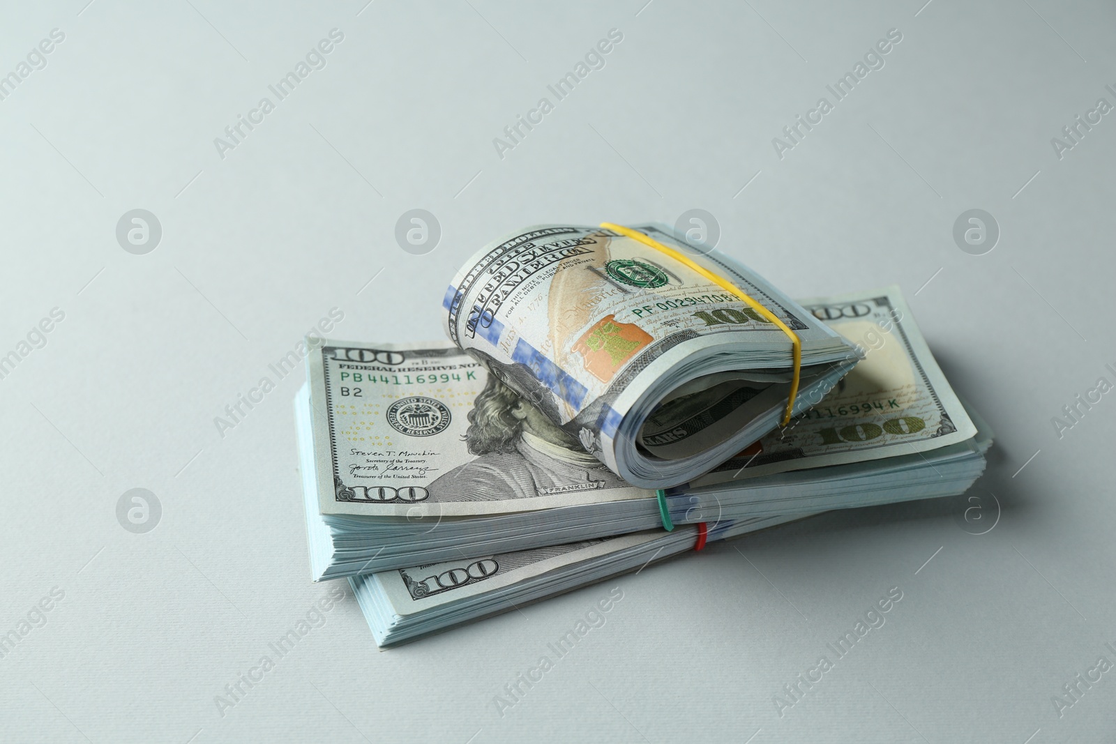 Photo of Bundles of dollar banknotes on light grey background