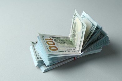 Photo of Bundles of dollar banknotes on light grey background