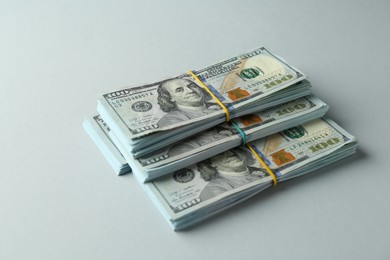 Photo of Bundles of dollar banknotes on light grey background