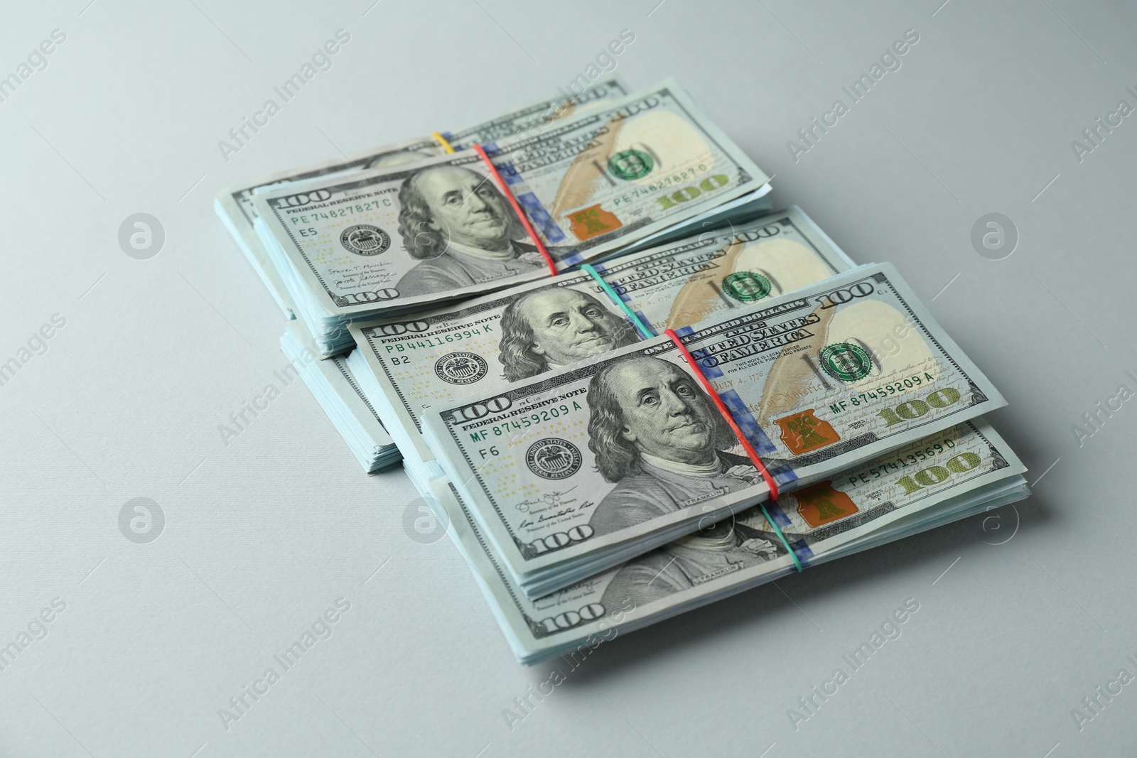 Photo of Bundles of dollar banknotes on light grey background