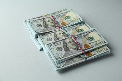 Photo of Bundles of dollar banknotes on light grey background