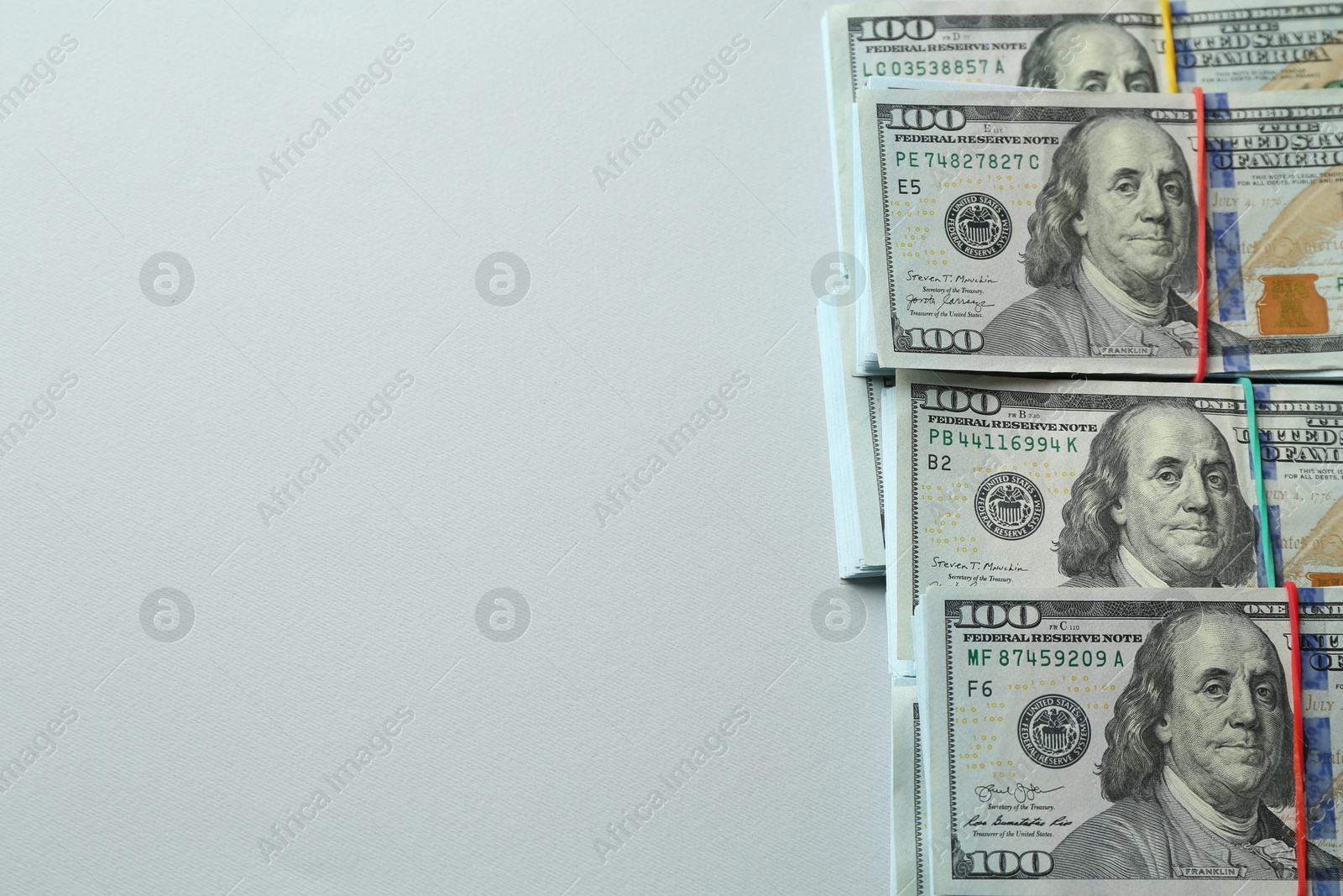 Photo of Bundles of dollar banknotes on light grey background, above view. Space for text