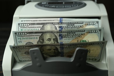 Money counter machine with dollar banknotes, closeup