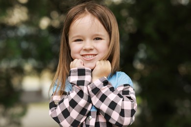 Portrait of happy little girl outdoors. Cute child