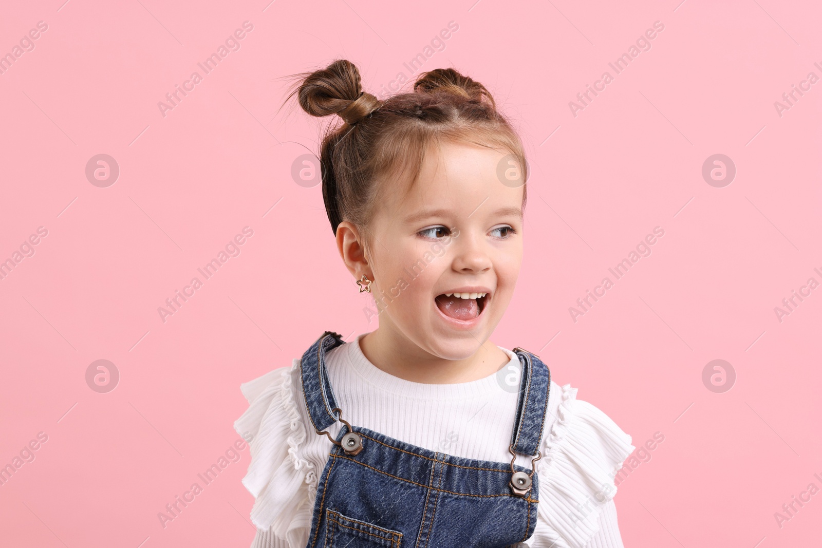 Photo of Portrait of emotional little girl on pink background