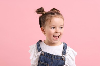 Portrait of emotional little girl on pink background