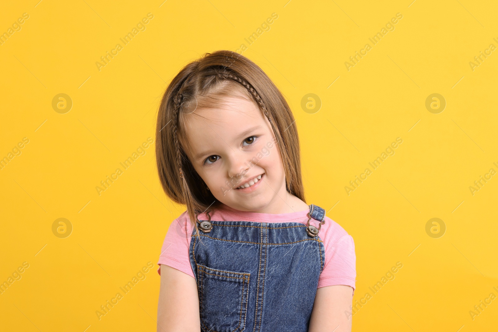 Photo of Portrait of happy little girl on orange background