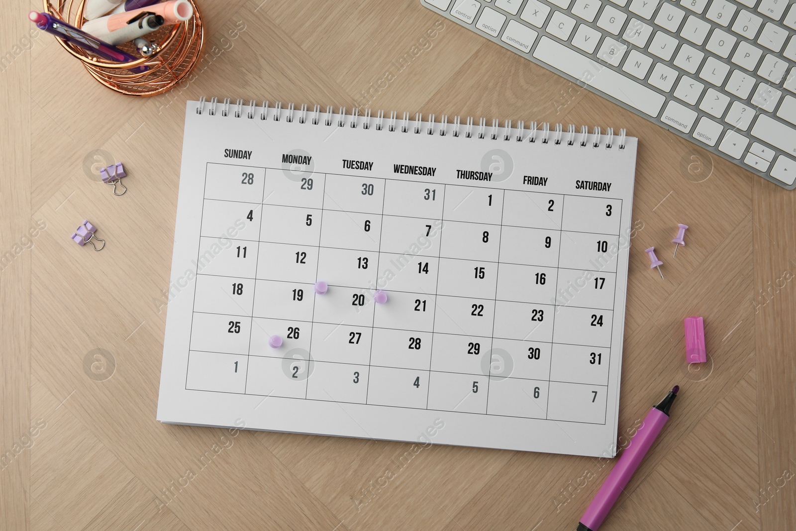 Photo of Timetable. Calendar, stationery and keyboard on wooden table, flat lay