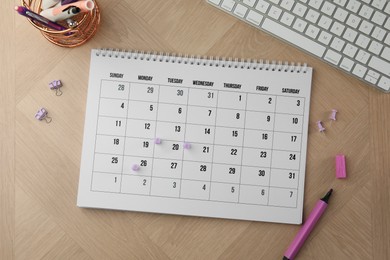 Timetable. Calendar, stationery and keyboard on wooden table, flat lay