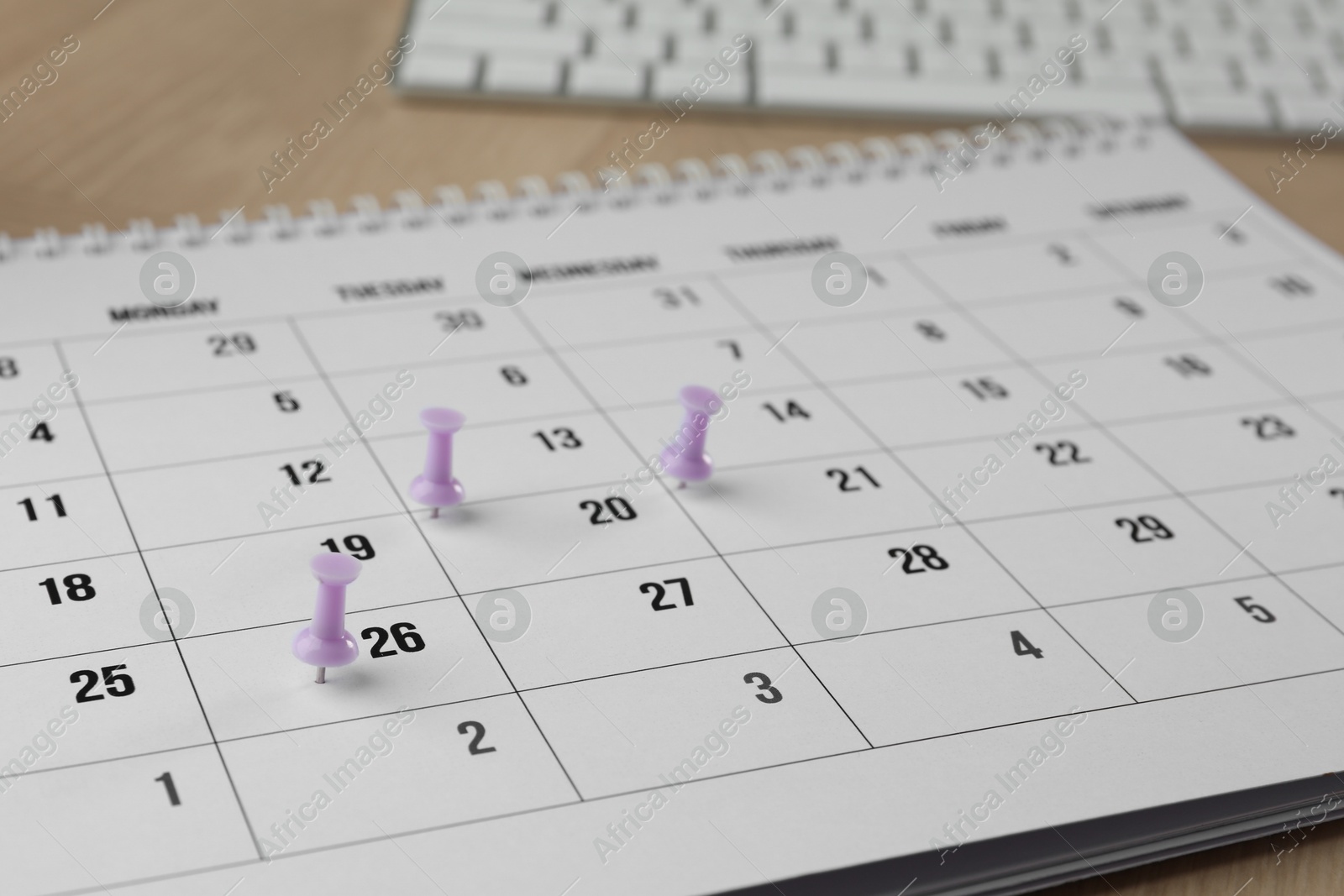 Photo of Timetable. Calendar page and drawing pins on table, closeup