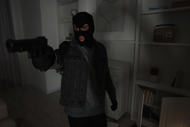 Photo of Thief with gun at foreign house. Burglary