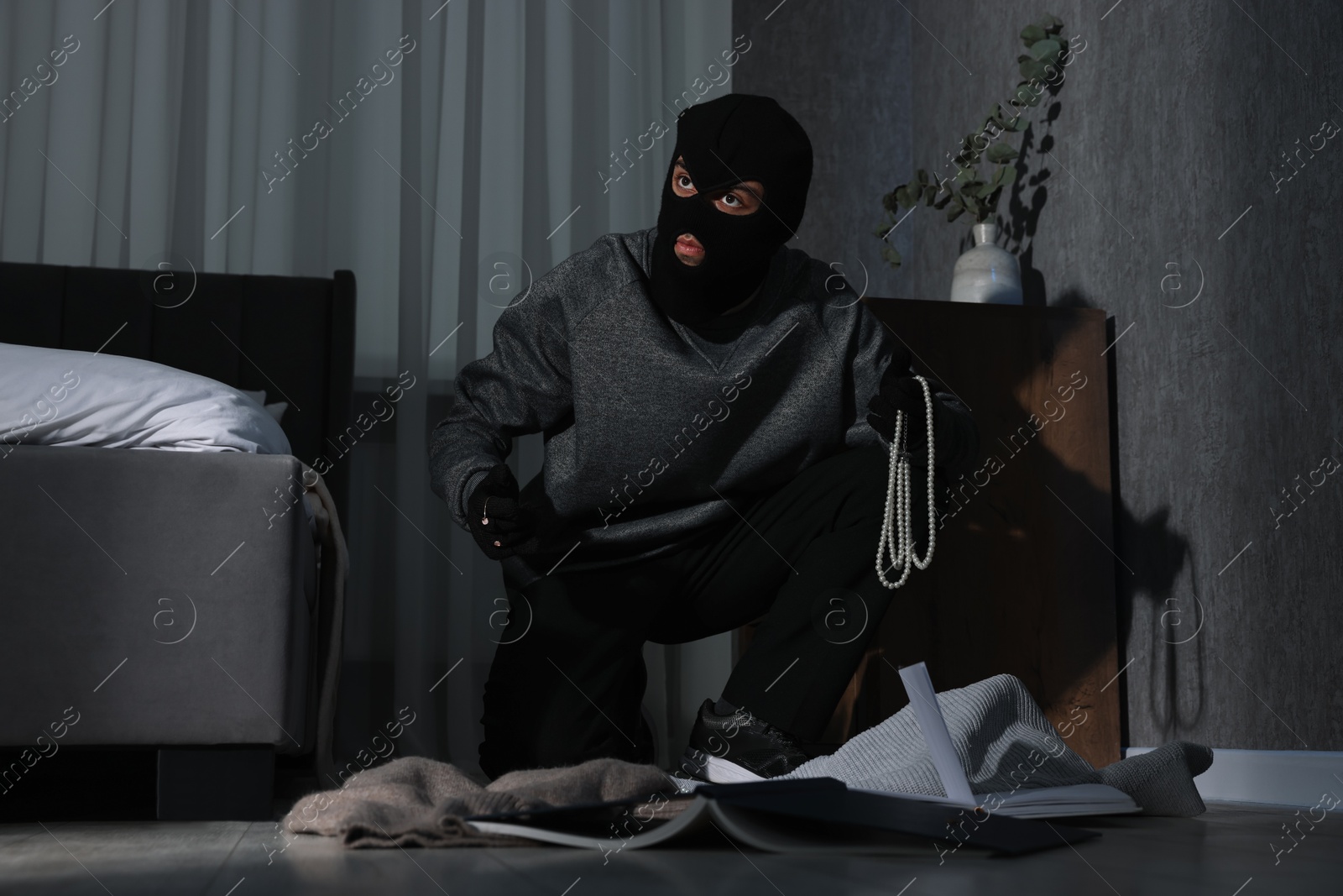 Photo of Thief stealing jewels in foreign house, low angle view. Burglary