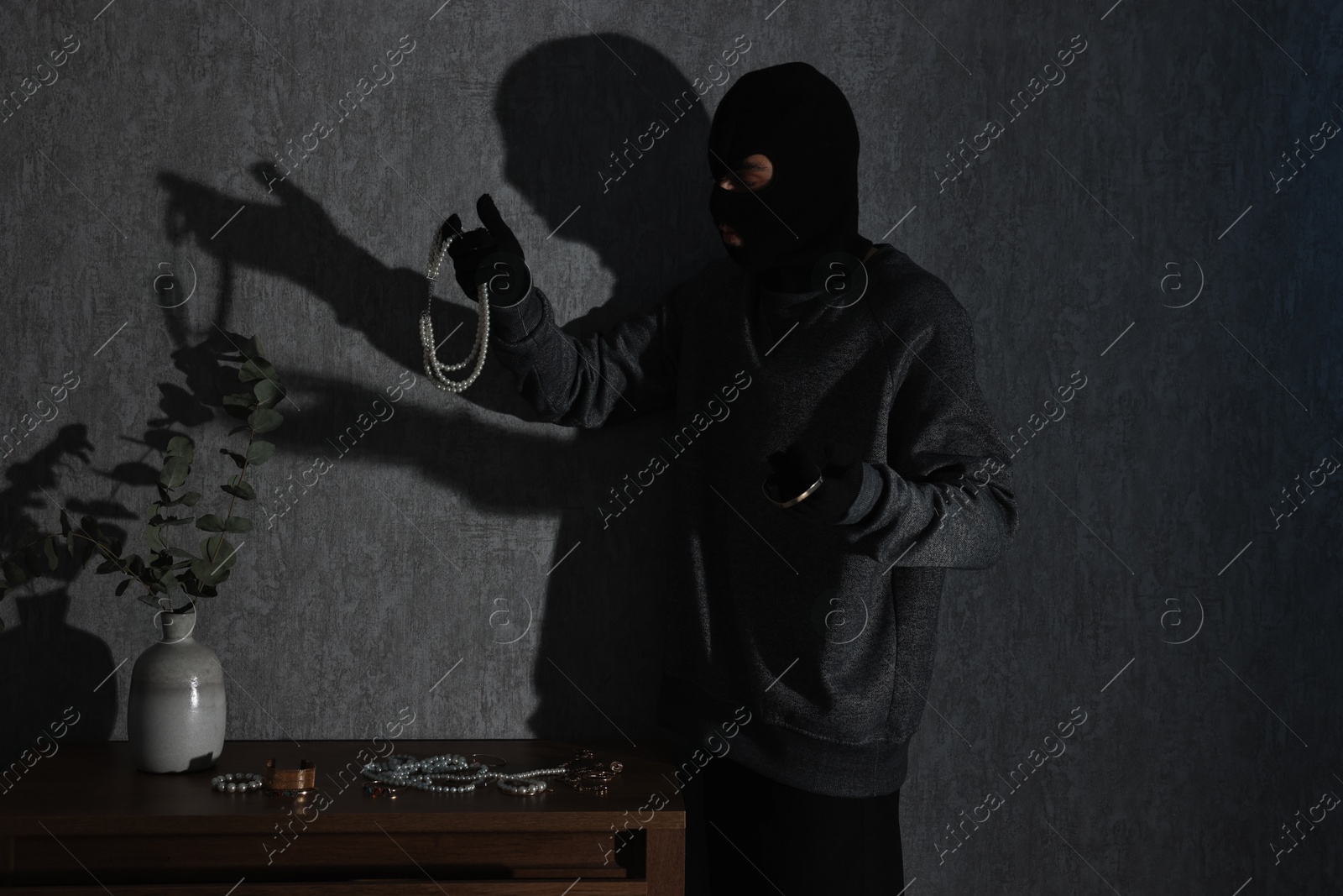 Photo of Thief stealing jewels in foreign house. Burglary