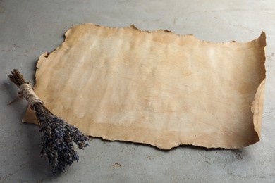 Sheet of old parchment paper and lavender flowers on grey table