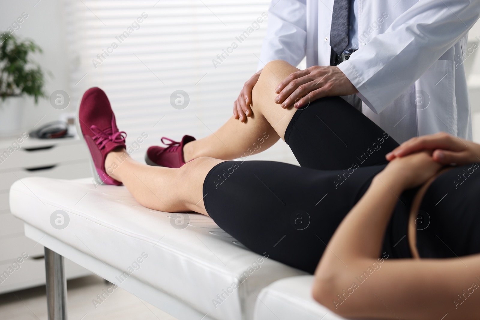 Photo of Sports injury. Doctor examining patient's leg in hospital, closeup