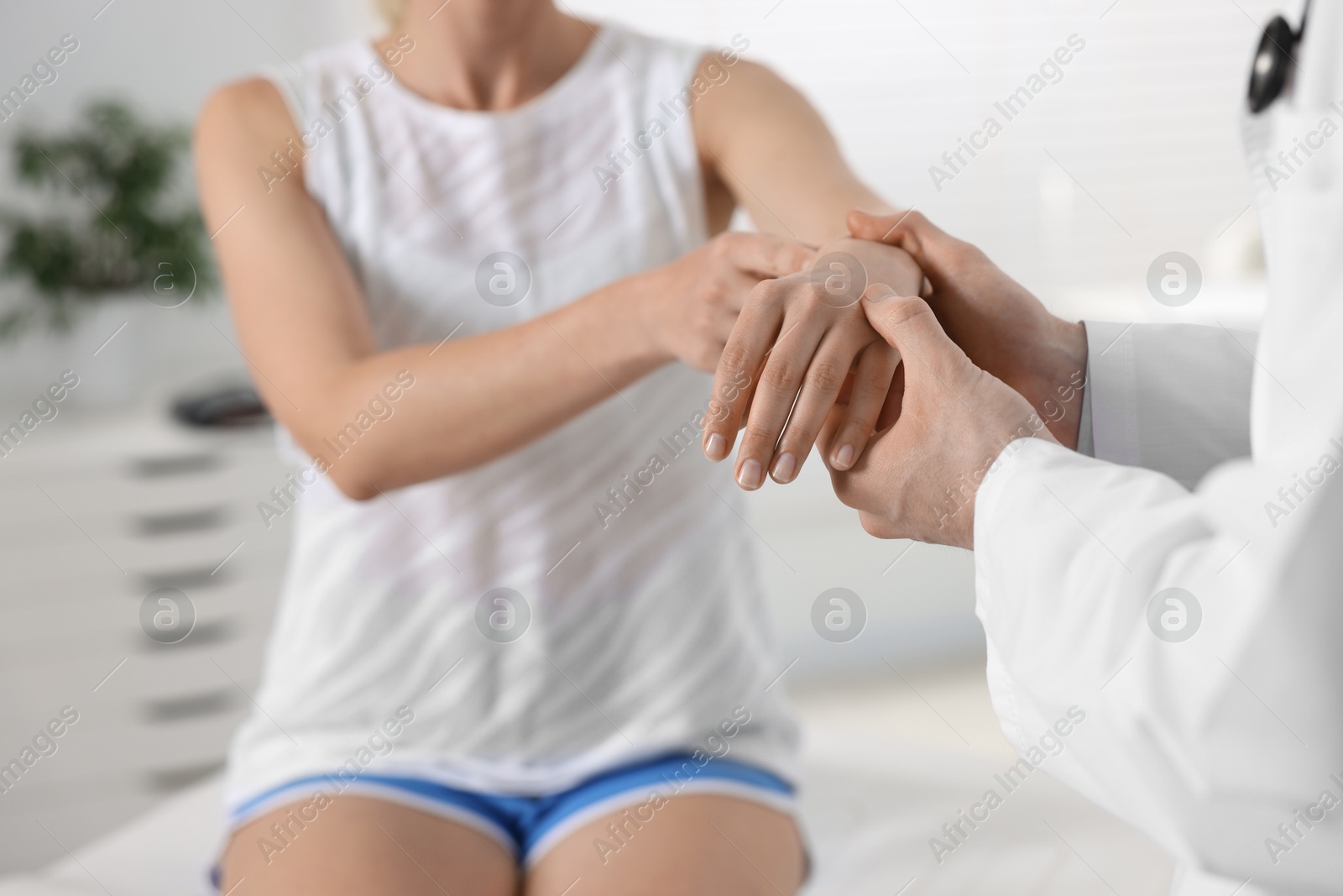 Photo of Sports injury. Doctor examining patient in hospital, closeup