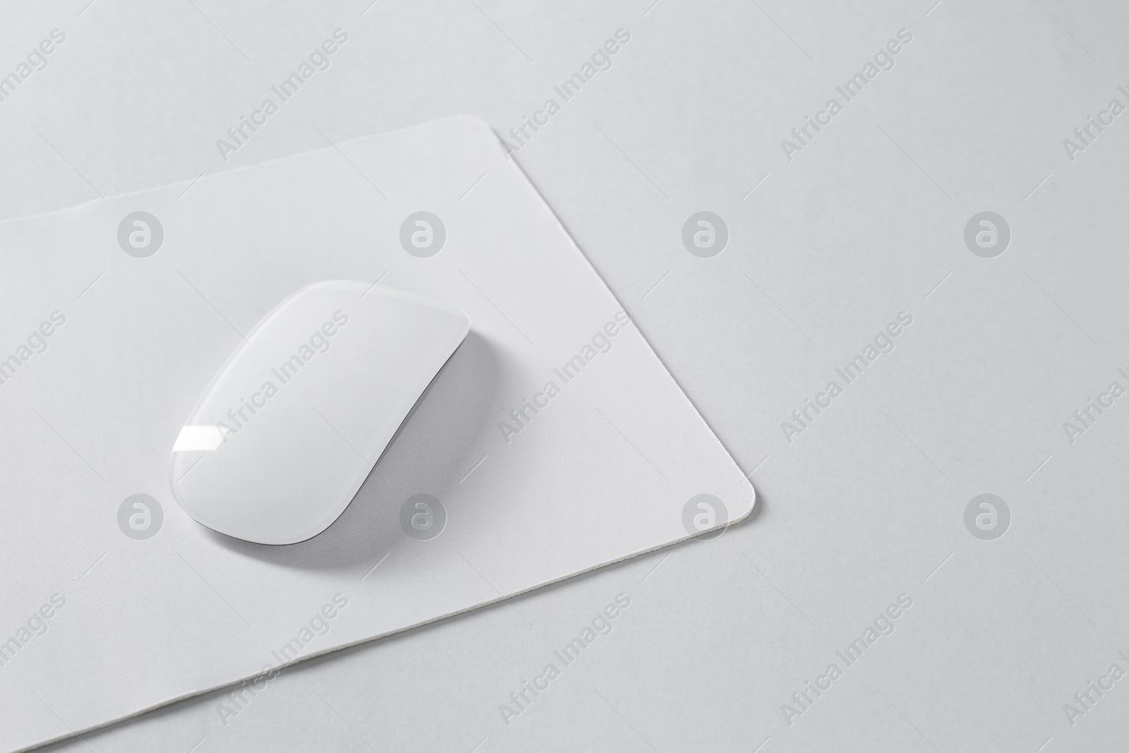 Photo of Wireless mouse and mousepad on white background, space for text