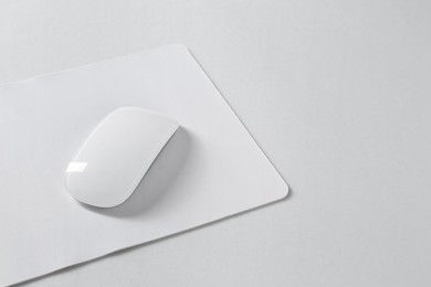 Photo of Wireless mouse and mousepad on white background, space for text