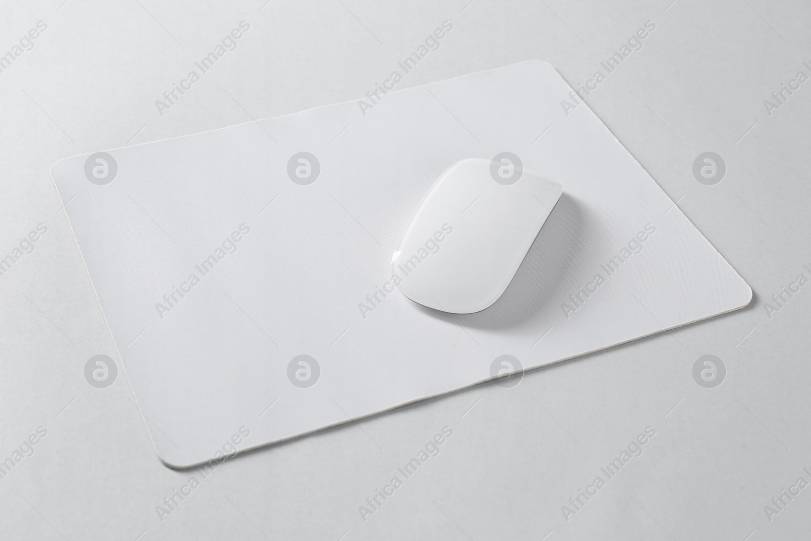 Photo of Wireless mouse and mousepad on white background