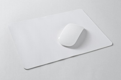 Photo of Wireless mouse and mousepad on white background