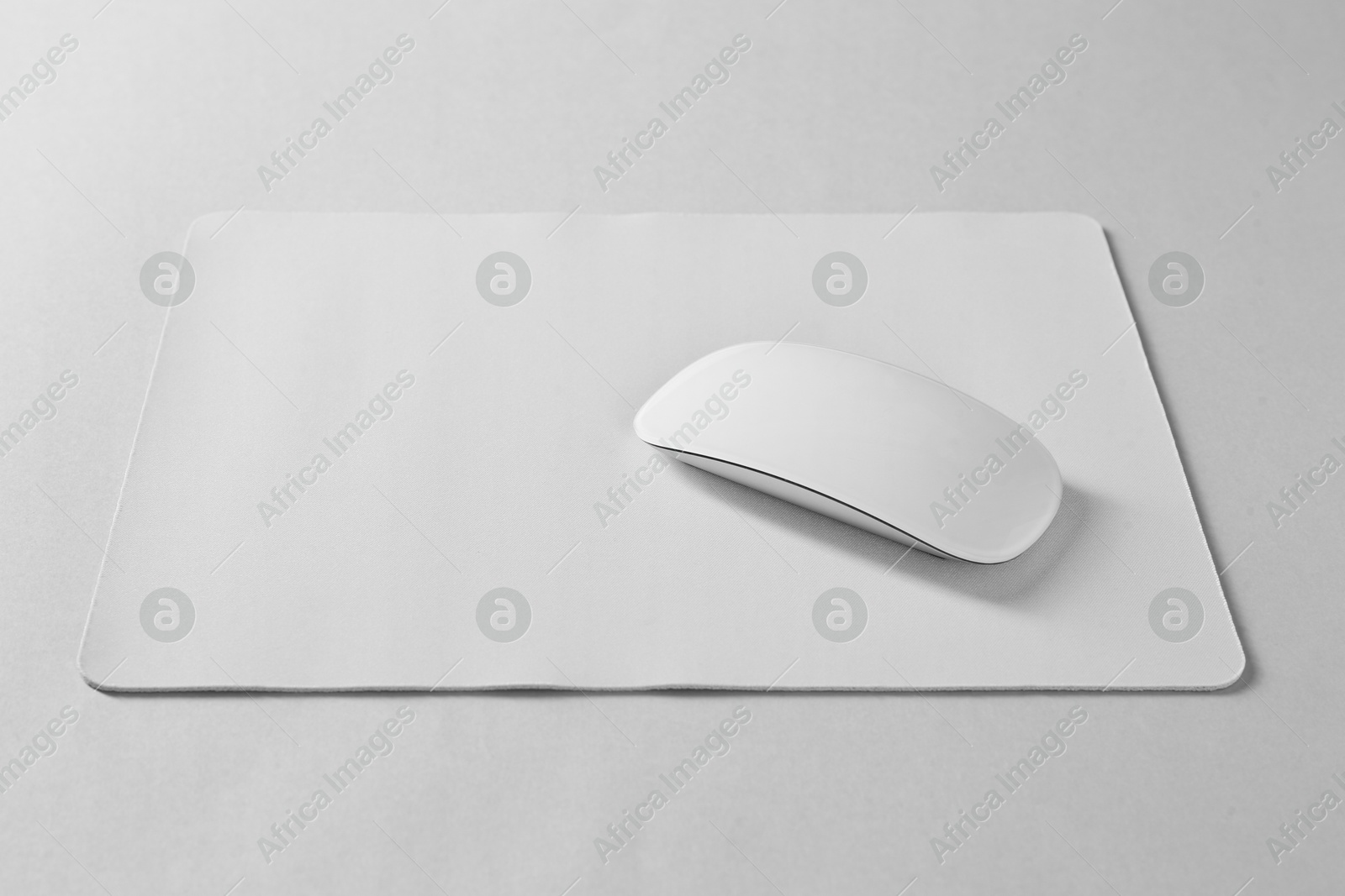 Photo of Wireless mouse and mousepad on white background