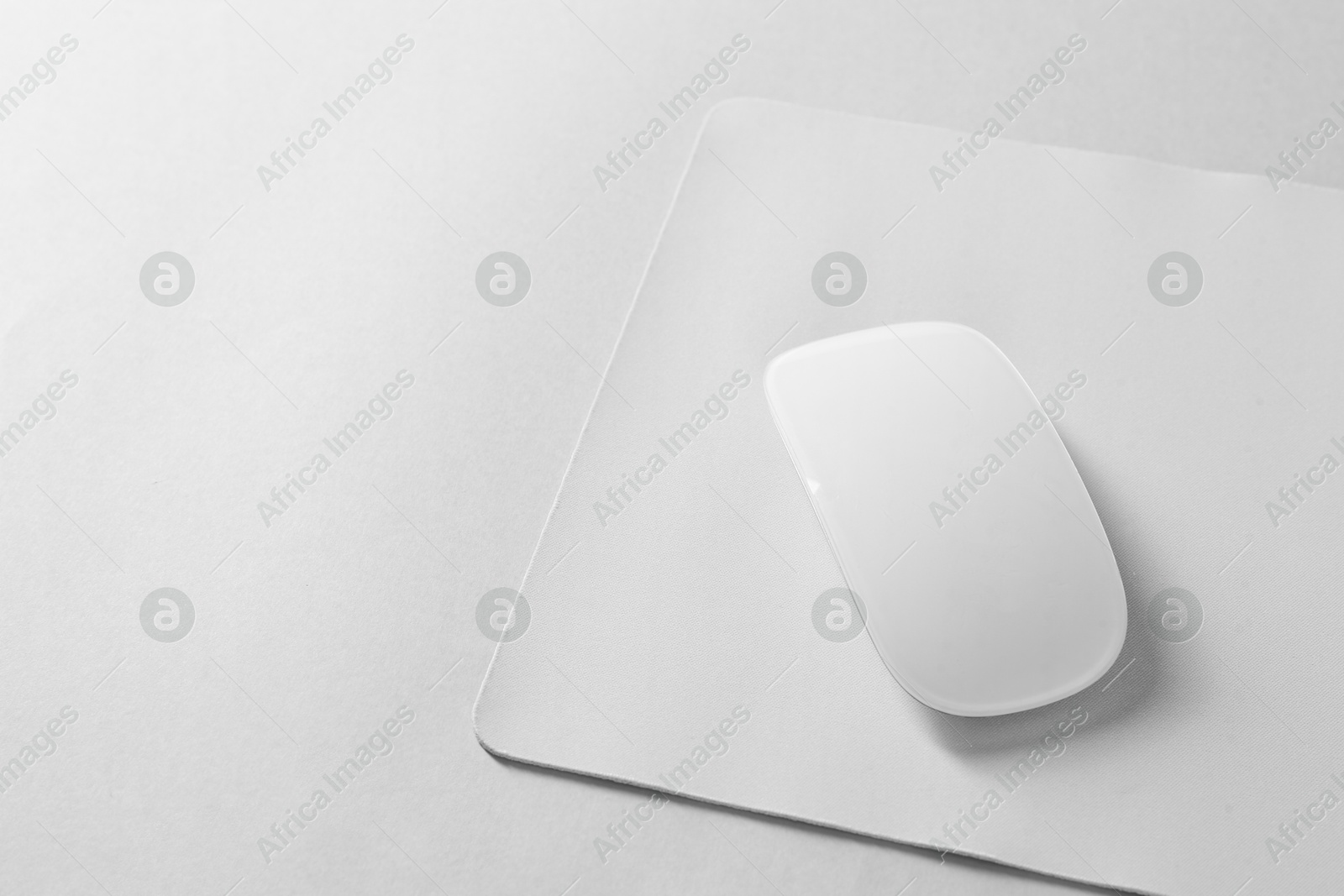 Photo of Wireless mouse and mousepad on white background, space for text