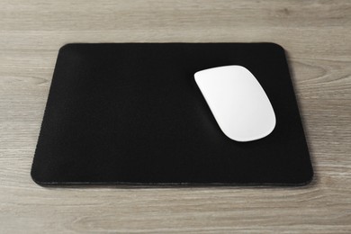 Wireless mouse and mousepad on wooden table