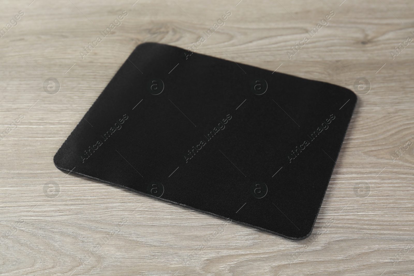 Photo of One black mouse pad on wooden table