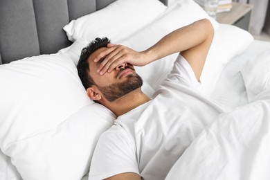 Morning of man suffering from headache in bed