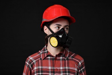 Photo of Woman in respirator and helmet on black background
