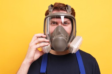 Photo of Man in respirator mask on yellow background