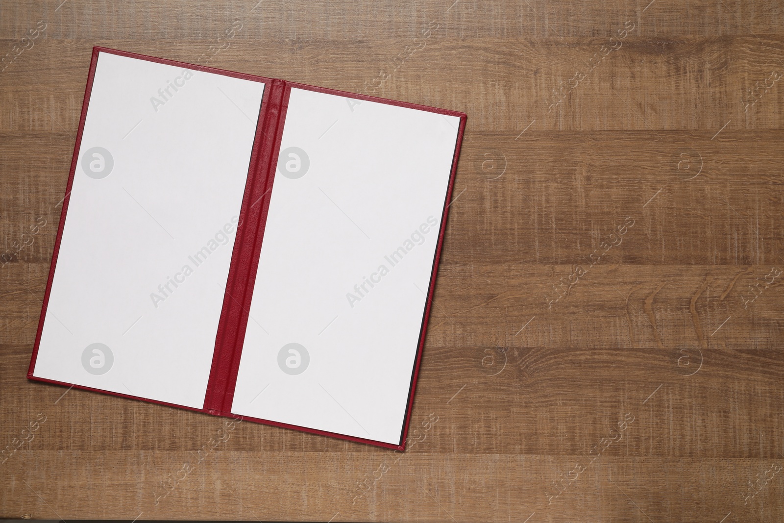 Photo of Hardcover notebook with blank sheets on wooden table, top view. Mockup for design