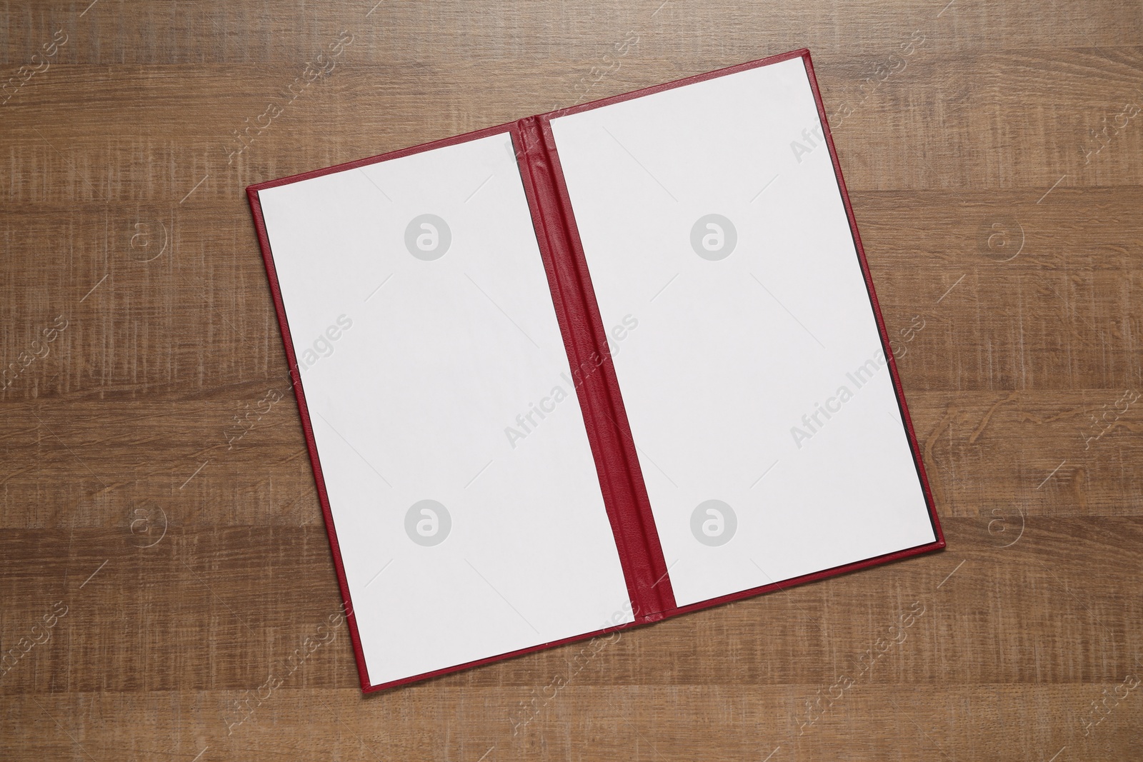 Photo of Hardcover notebook with blank sheets on wooden table, top view. Mockup for design