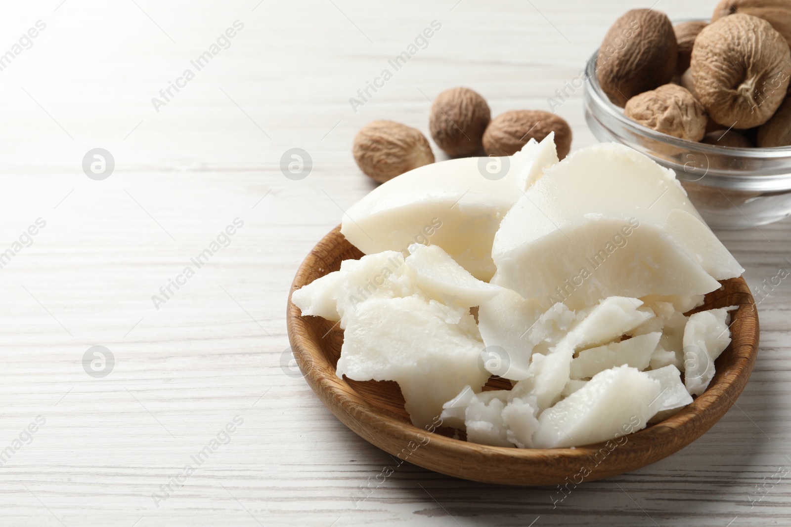 Photo of Natural shea butter and nuts on wooden table, space for text