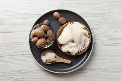 Photo of Natural shea butter and nuts on wooden table, top view