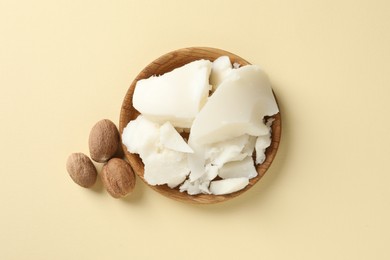 Natural shea butter and nuts on beige background, top view