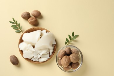 Photo of Natural shea butter, nuts and green leaves on beige background, top view. Space for text