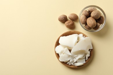 Photo of Natural shea butter and nuts on beige background, top view. Space for text