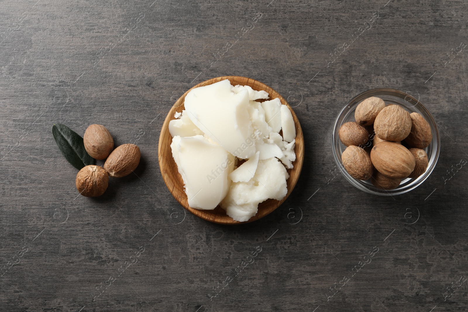 Photo of Natural shea butter and nuts on grey table, top view