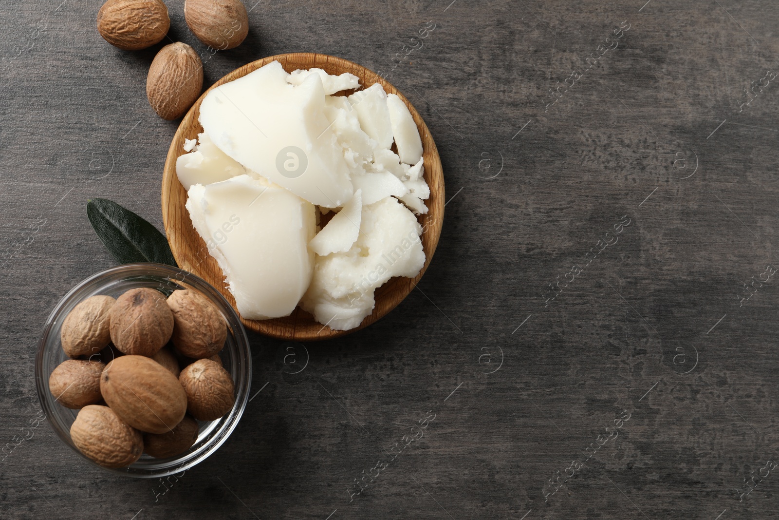 Photo of Natural shea butter and nuts on grey table, top view. Space for text