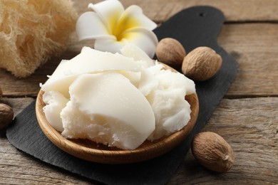 Natural shea butter, nuts, plumeria flower and loofah sponge on wooden table