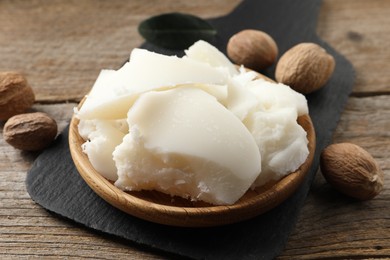 Natural shea butter and nuts on wooden table, closeup