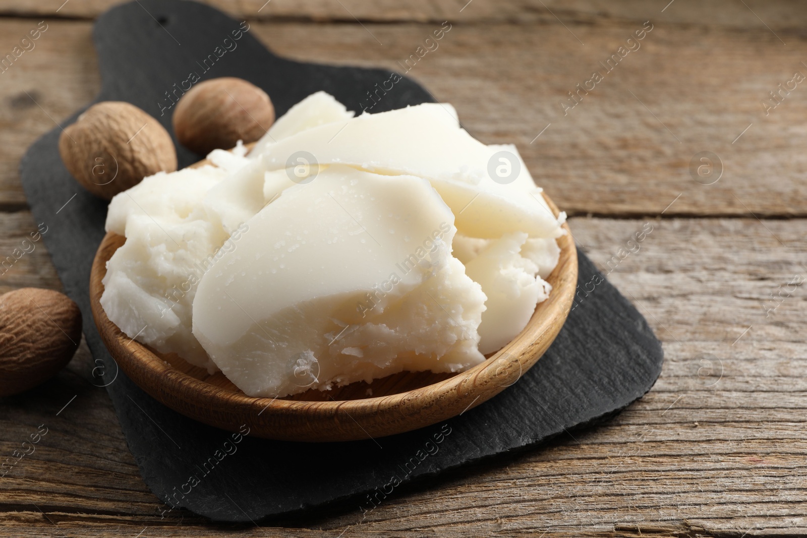 Photo of Natural shea butter and nuts on wooden table